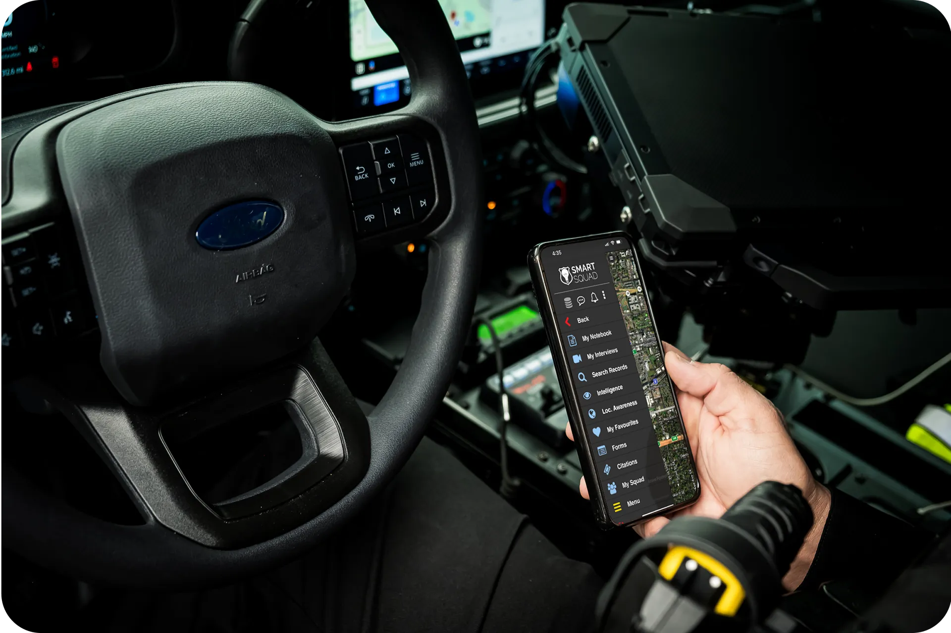 Officer using Smart Squad on a mobile device inside a patrol vehicle